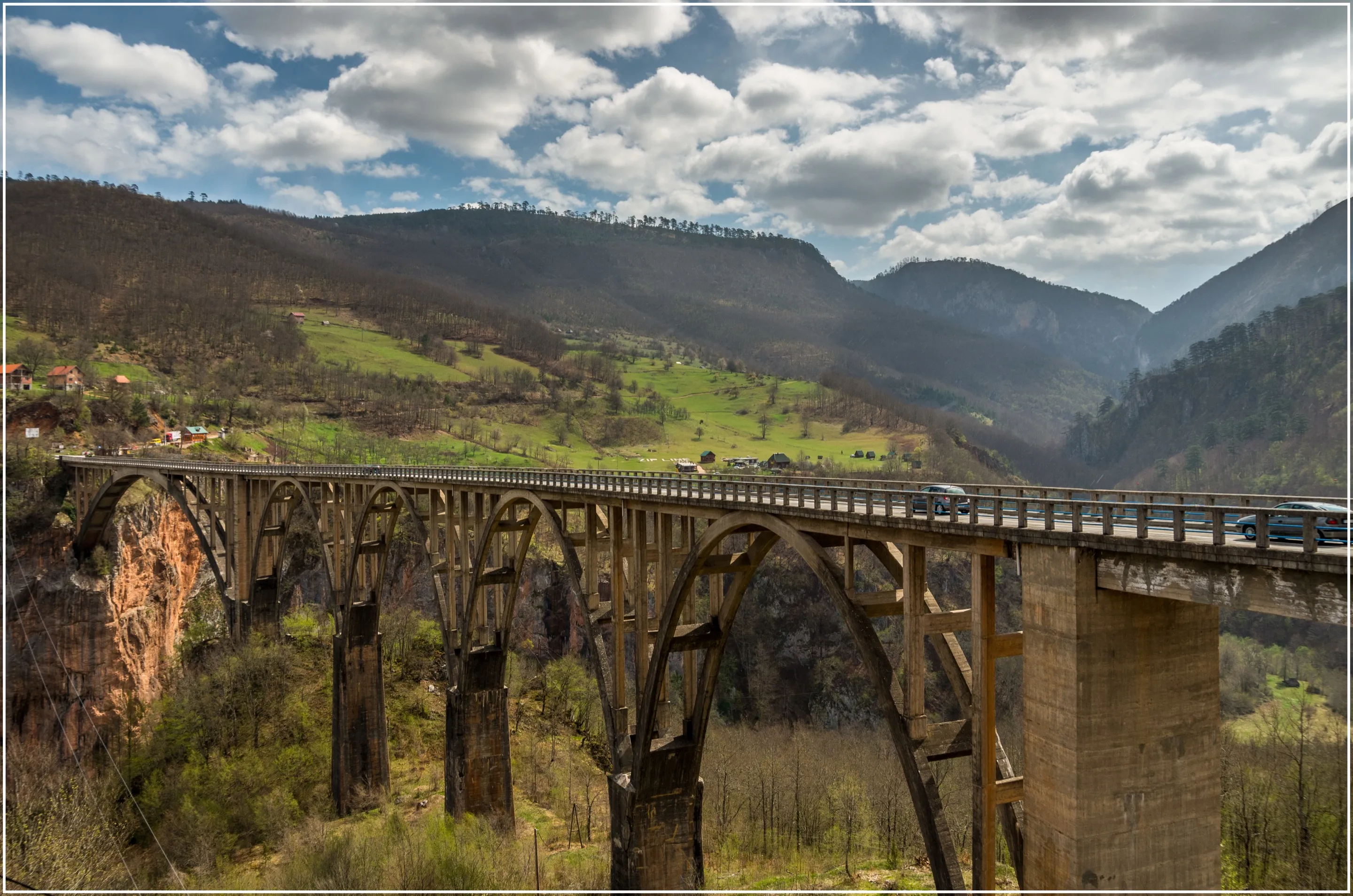 A five-arch concrete bridge crossing the Tara canyon under a cloudy sky.