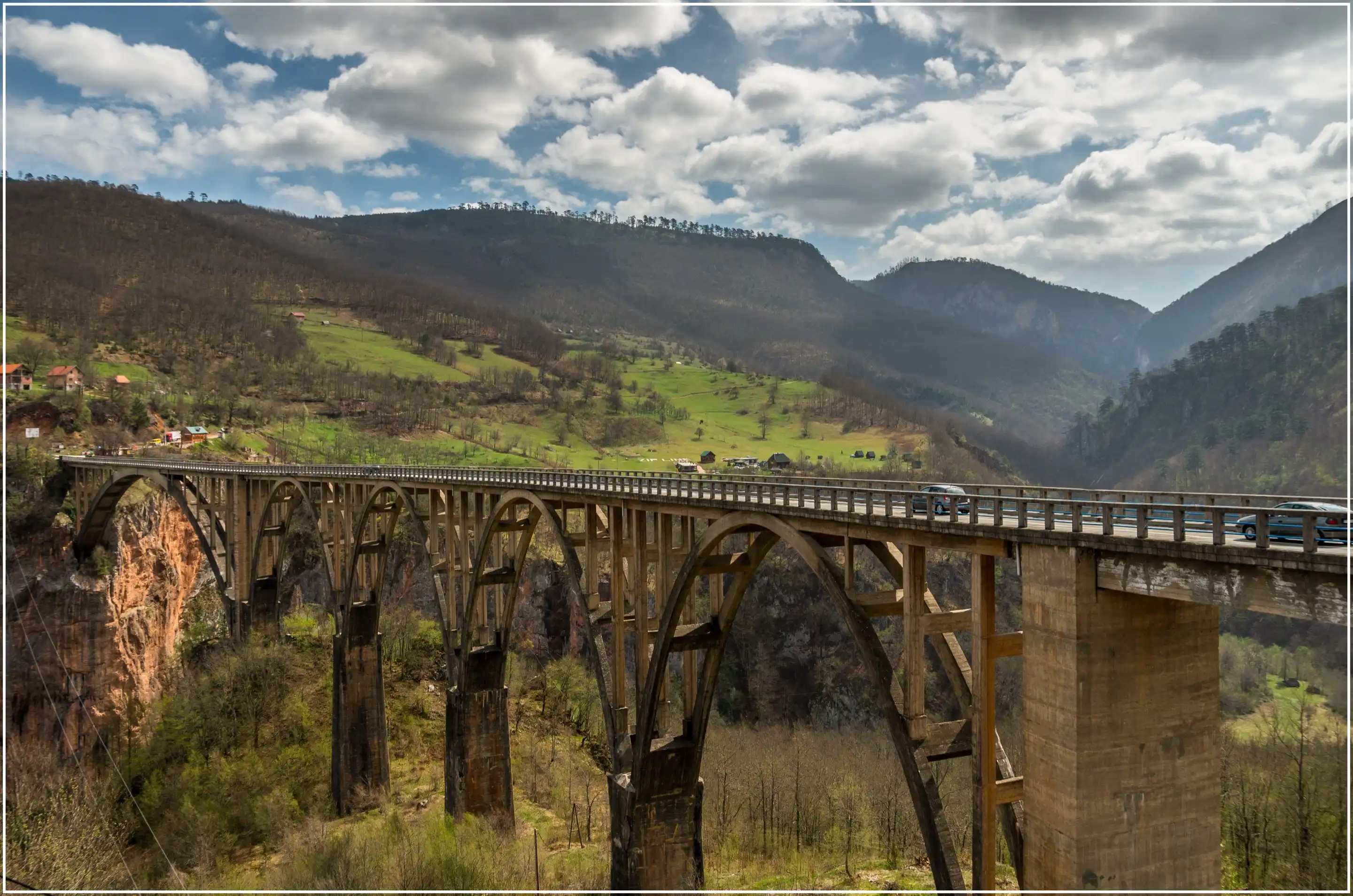 A five-arch concrete bridge crossing the Tara canyon under a cloudy sky.