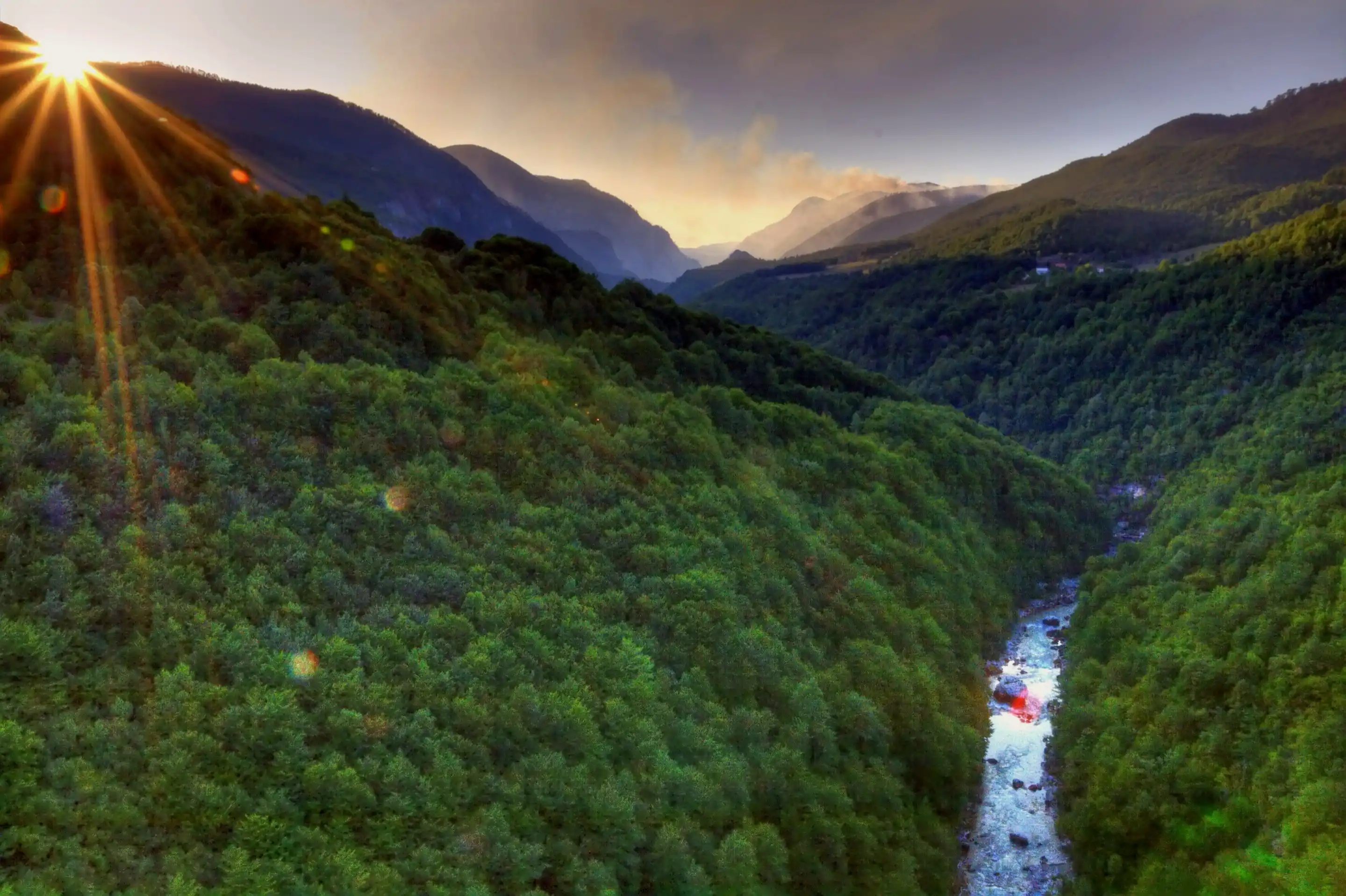 The Tara river deep in its canyon at sunset, the sun breaking over a forested ridge.